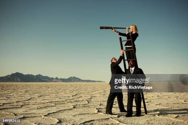small business team search through telescope on salt flats - long hair stock pictures, royalty-free photos & images