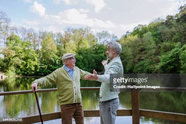 mature son and his senior father greeting together. - nonni bastone foto e immagini stock