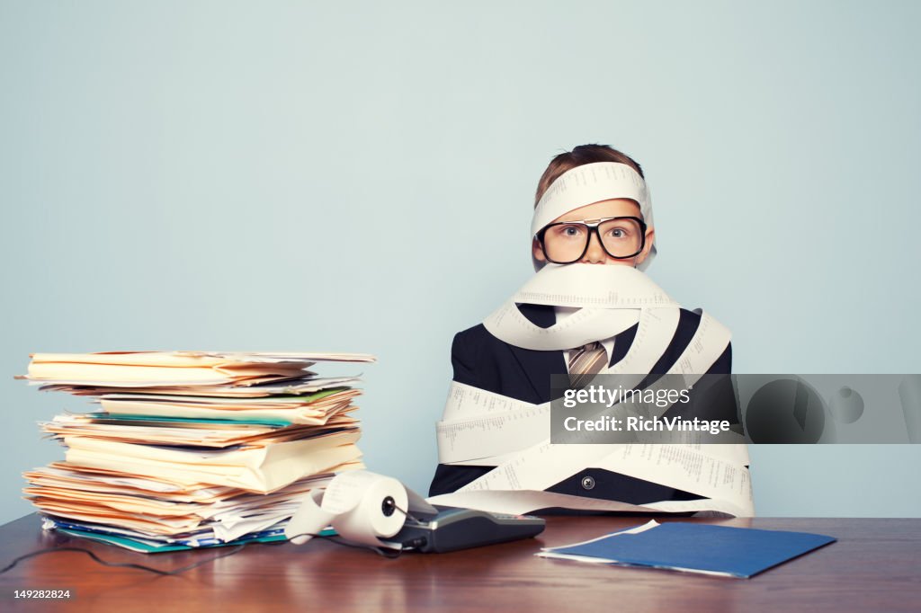 Boy Accountant Overworked and Covered in Paper