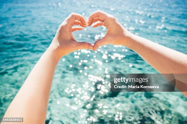 personal perspective of woman's hand under above clear turquoise water. - women flashing stock pictures, royalty-free photos & images