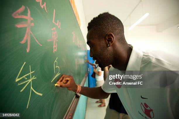 In this handout image provided by Arsenal FC, Johan Djourou writes on a blackboard as he visits the Miaopu Huanghuang School which is funded by Save...
