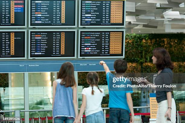 family looking at arrival departure board, rear view - farewell in 2012 stock pictures, royalty-free photos & images