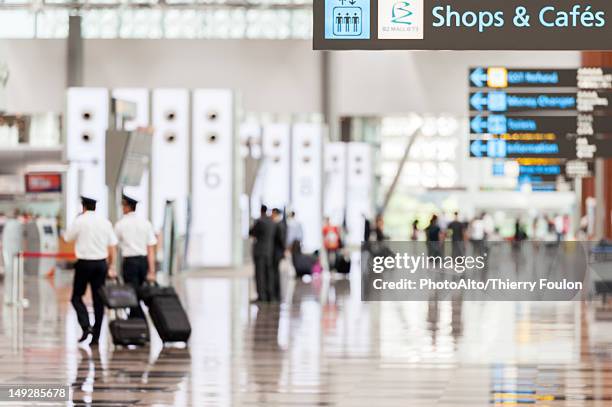 signs in airport concourse - singapore airport stock pictures, royalty-free photos & images
