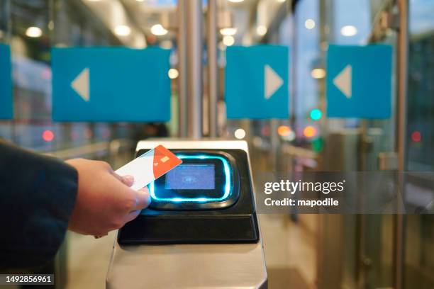 commuter swiping a contactless pass at a bus stop turnstile - bus pass stockfoto's en -beelden