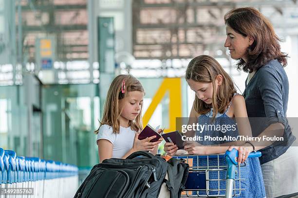 mother and daughters standing outside of airport with luggage - kid in airport stock-fotos und bilder