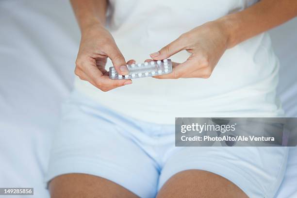 woman holding birth control pills, mid section - antibabypille stock-fotos und bilder