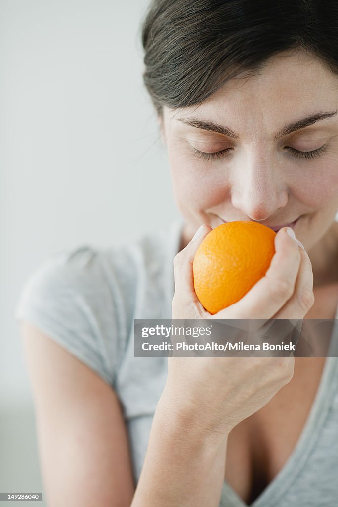 Woman smelling fresh orange