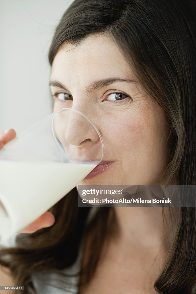 Mid-adult woman drinking glass of milk