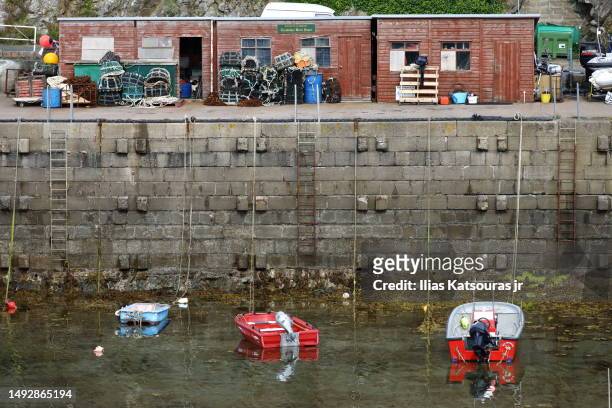 boats moored in small port with vertical wall and wooden cabins - jr wall stock pictures, royalty-free photos & images