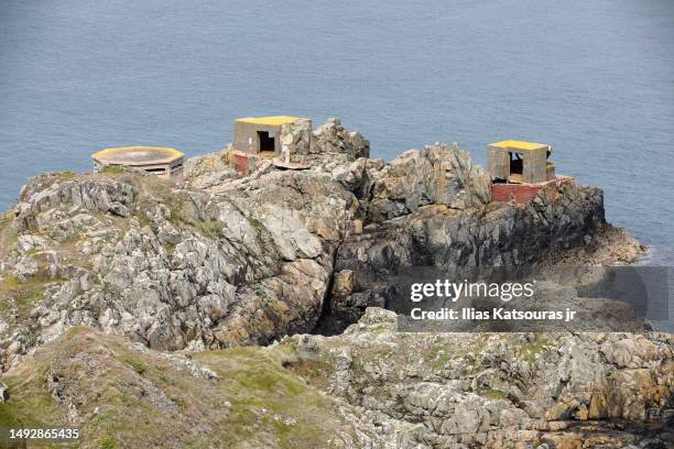 concrete wwii bunkers and fortification structures on rocky peninsula - government building background stock pictures, royalty-free photos & images