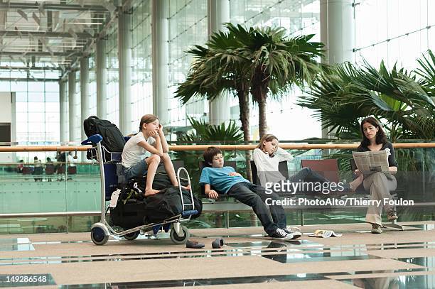 family waiting in airport terminal - family at airport stock pictures, royalty-free photos & images