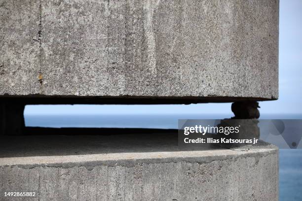 detail of concrete wwii naval tower with defocused sea in background - government building background stock pictures, royalty-free photos & images