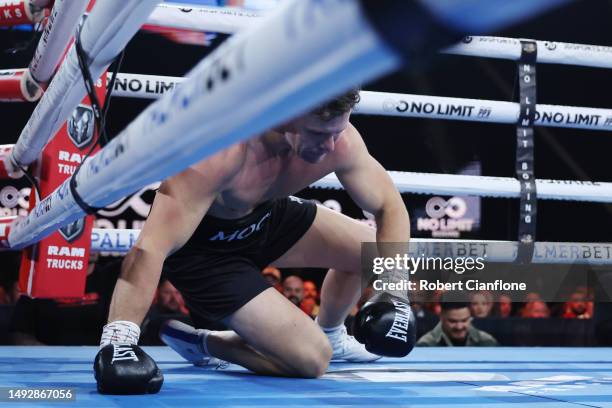 Cameron Mooney falls to the floor during his Heavyweight bout against Tom Bellchambers at Margaret Court Arena on May 24, 2023 in Melbourne,...