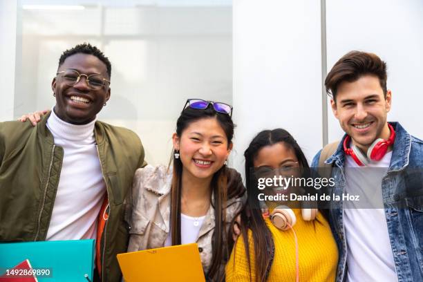 portrait of happy and smiling multiracial group of college student friends looking at camera. - laatstejaars high school stockfoto's en -beelden