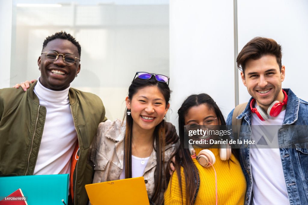 Portrait of happy and smiling multiracial group of college student friends looking at camera.
