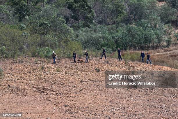 German and Portuguese Judiciary police members walk with a specially trained dog to the search area by the waterline for remains of Madeleine McCann...