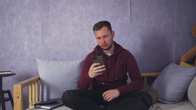 Businessman Checking Finances on Phone At Home