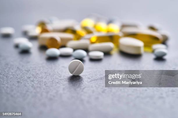 tablets, vitamins and dietary supplements on a dark table. - folic acid stock pictures, royalty-free photos & images