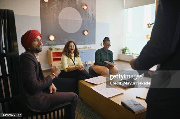 diverse group of engineers team members engaged in a conversation - sikhism stock pictures, royalty-free photos & images