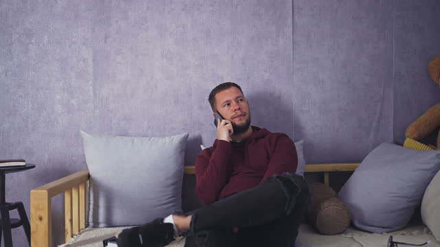 Male Student Having a Phone Chat from the Comfort of Home