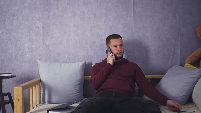 Relaxed Student Talking on Smartphone in Comfortable Living Room