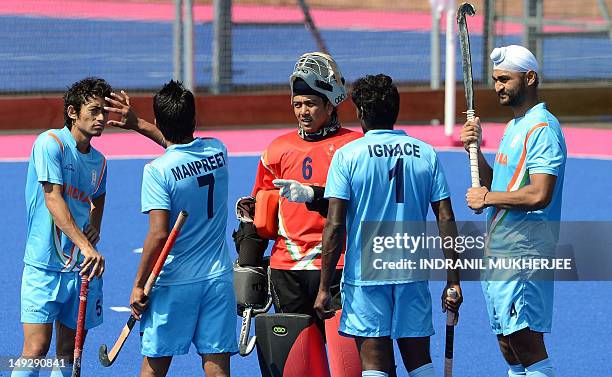 Indian men's field hockey team captain Bharat Chetri speaks to teammates during a break in training session at the Old Loughtonians Hockey Club at...