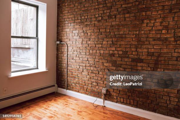 estudio vacío de nueva york con una pared de ladrillo junto a una ventana - new york apartment interior fotografías e imágenes de stock