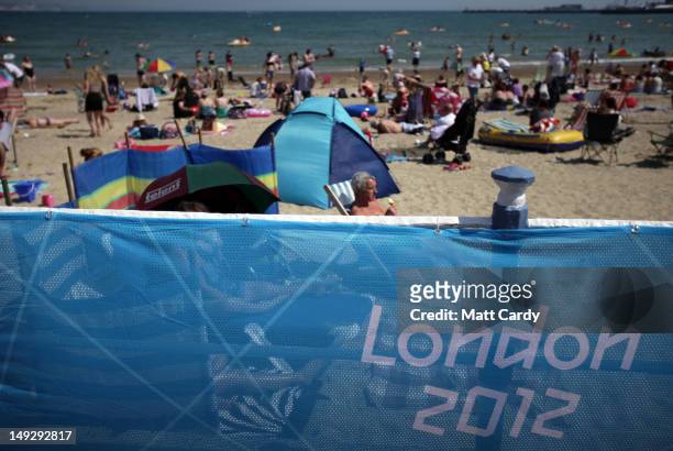 People enjoy the fine weather as they sit on the beach as Weymouth gears up to host the London 2012 sailing events, on July 26, 2012 in Weymouth,...