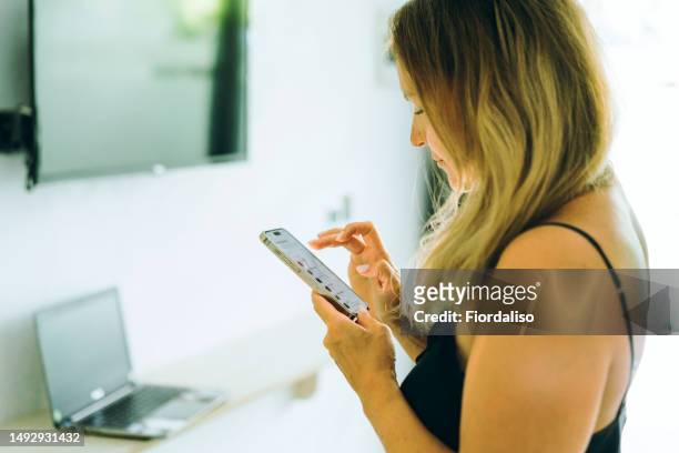 woman in the hotel room with mobile phone - search bar stock pictures, royalty-free photos & images