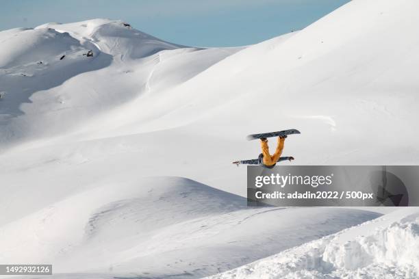 man jumping on snowcapped mountain against sky,algeria - extreme skiing photos et images de collection