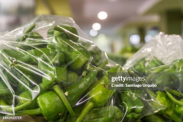 close-up of green peppers in plastic bag for sale - a coruna stock-fotos und bilder