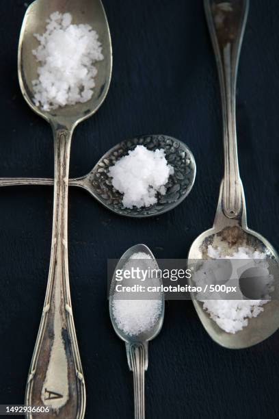 high angle view of silver spoons with salt on black background,portugal - colher de sopa imagens e fotografias de stock