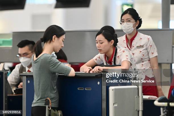 Attendants serve a passenger at the Cathay Pacific Airways Ltd. Check-in area at the Hong Kong International Airport on May 24, 2023 in Hong Kong,...