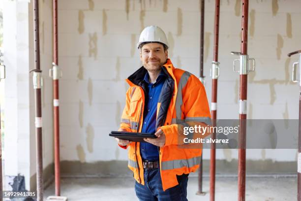 bauarbeiter steht auf der baustelle - bauarbeiter stock-fotos und bilder