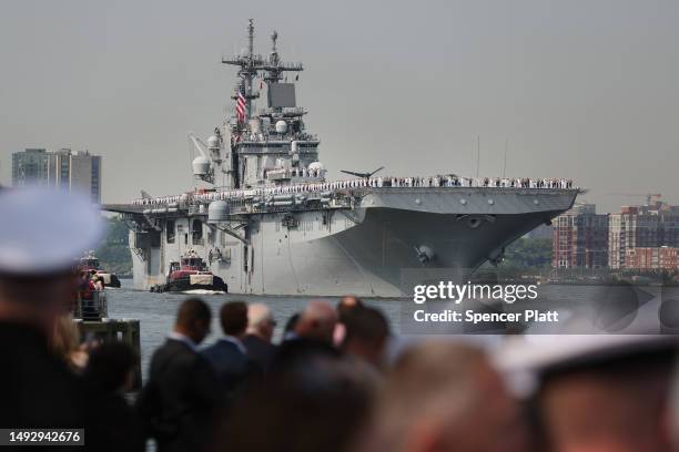 Service men and women watch from the the Intrepid Sea, Air & Space Museum as the USS Wasp, an amphibious assault ship from Norfolk, Virginia, arrives...