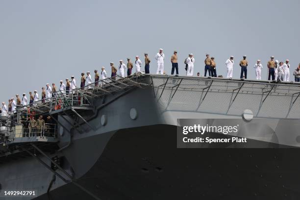 Service men and women stand on deck of the USS Wasp, an amphibious assault ship from Norfolk, Virginia, as it arrives into New York Harbor on...