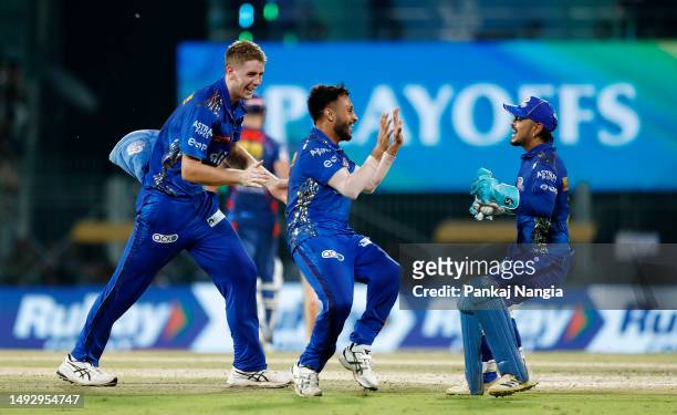 Akash Madhwal of Mumbai Indians celebrates with teammates after taking the wicket of Nicholas Pooran of Lucknow Super Giants during the IPL...