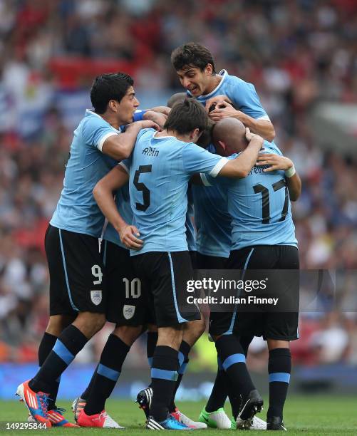 Gaston Ramirez of Uruguay is congratulated by team mates after scoring a goal during the Men's Football first round Group A Match of the London 2012...