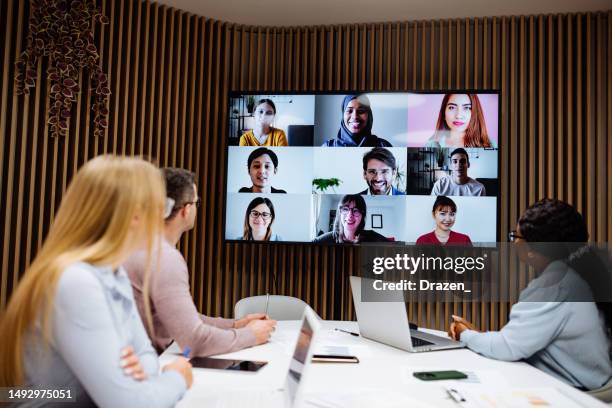 group of diverse business people talking to remote colleagues over video link. telecommuting in global business. - corporate virtual event stock pictures, royalty-free photos & images