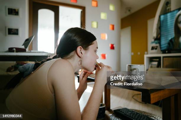 portrait of a teenager girl eating at home - childhood obesity stock pictures, royalty-free photos & images