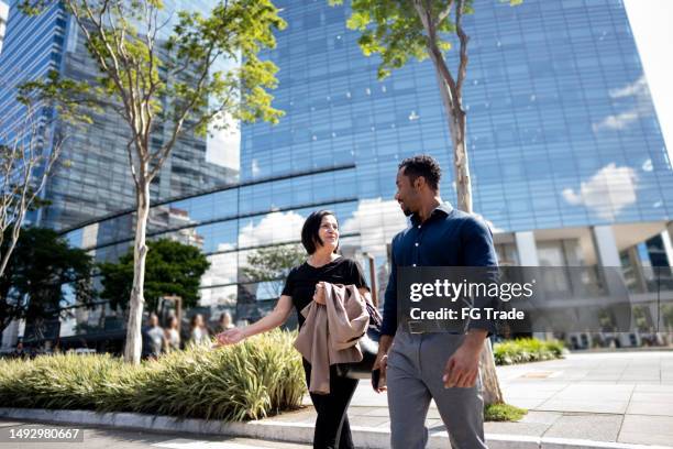 compañeros de trabajo hablando mientras caminan por la calle - paso peatonal raya indicadora fotografías e imágenes de stock
