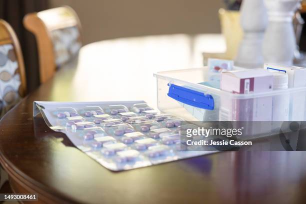 packet of pills beside container of medication on table - double effort stock pictures, royalty-free photos & images
