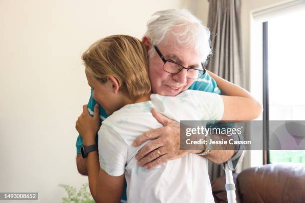 senior man with dementia hugging young teen-aged boy - dementia father stock pictures, royalty-free photos & images