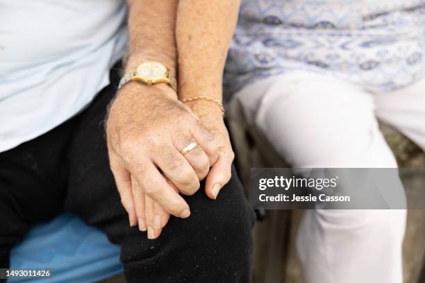 close up of senior couple's hands held together resting on leg - mental illness stock pictures, royalty-free photos & images