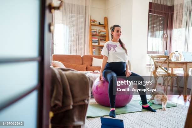 mujer embarazada hace ejercicios con pelota de pilates en casa - yoga ball fotografías e imágenes de stock