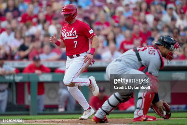 Spencer Steer of the Cincinnati Reds scores a run past Willson Contreras of the St. Louis Cardinals in the first inning at Great American Ball Park...