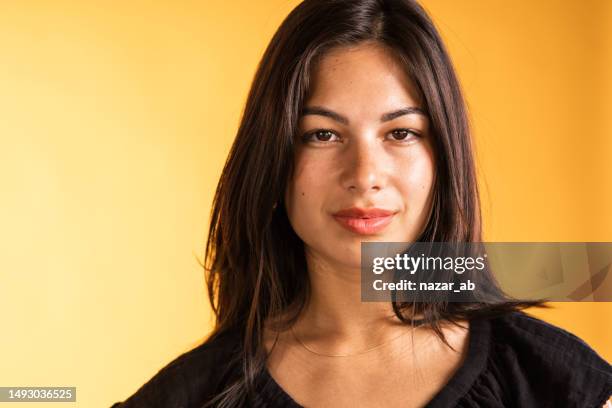 confident woman looking at camera isolated against yellow backdrop. - eurasian ethnicity stock pictures, royalty-free photos & images