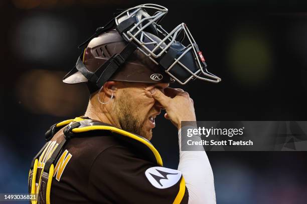 Brett Sullivan of the San Diego Padres reacts after being hit by the bat of Jeimer Candelario of the Washington Nationals on a followthrough during...