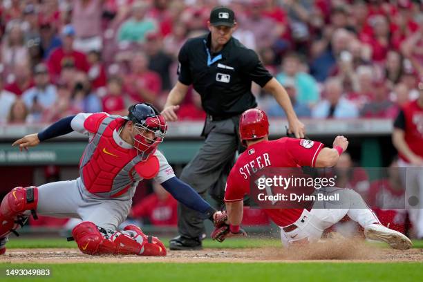 Willson Contreras of the St. Louis Cardinals tags out Spencer Steer of the Cincinnati Reds at home plate in the fourth inning at Great American Ball...