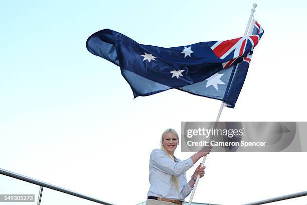 Basketballer Lauren Jackson waves the Australian flag after being announced as the Australian flag bearer at the Australian Olympic Committee 2012...